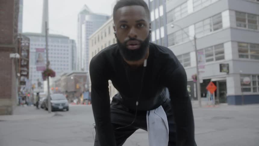 A man dribbles a basketball on the sidewalk