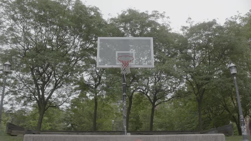 Basketball thrown across to a basket hoop and retrieved by a man