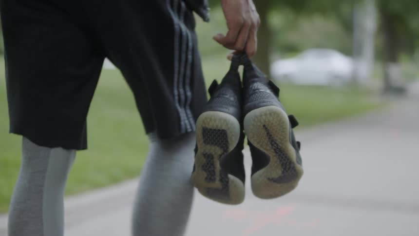 A man carrying shoes walking down the street