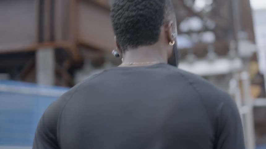 African american man walks down street listening to music