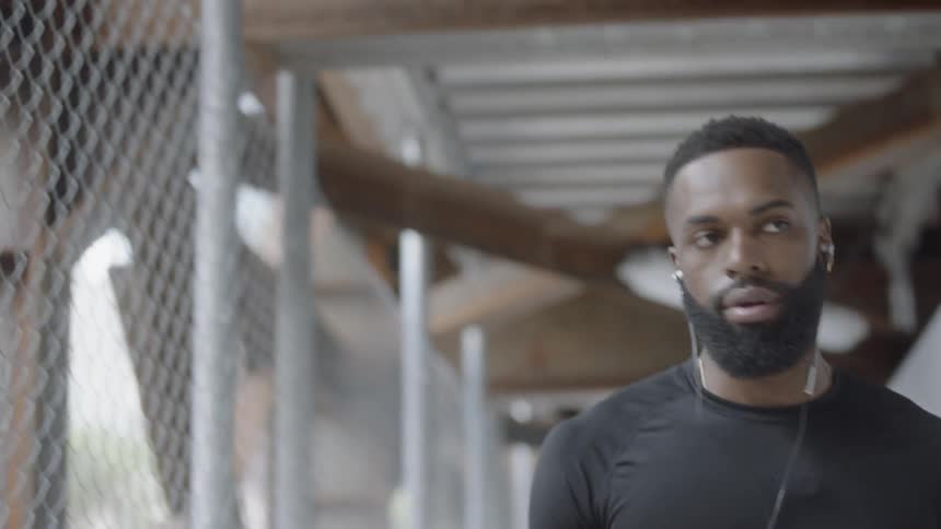 Man walking down alley way with basketball