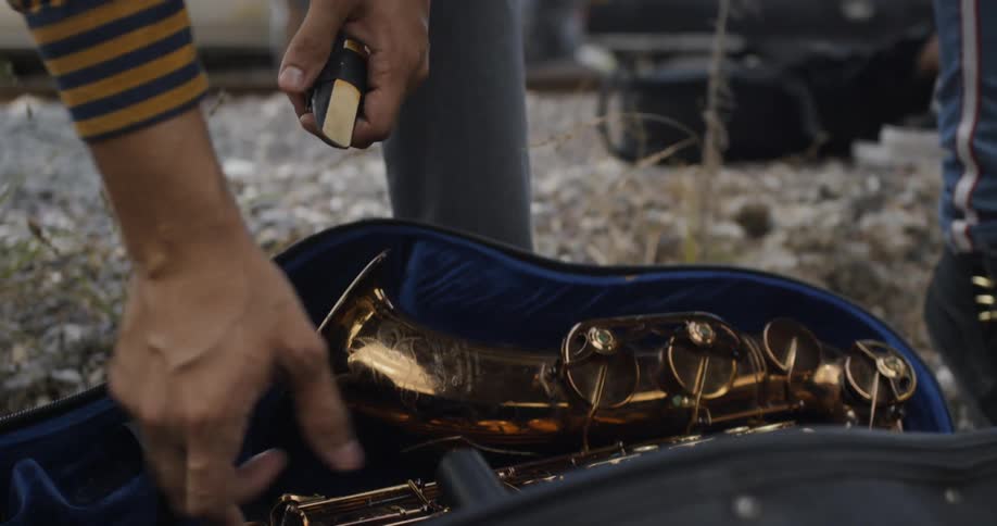 A man is unpacking a saxophone from its protective case