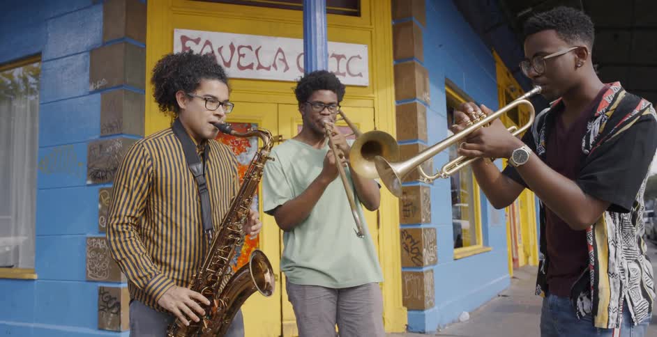 Group of black friends playing wind instruments together at street corner