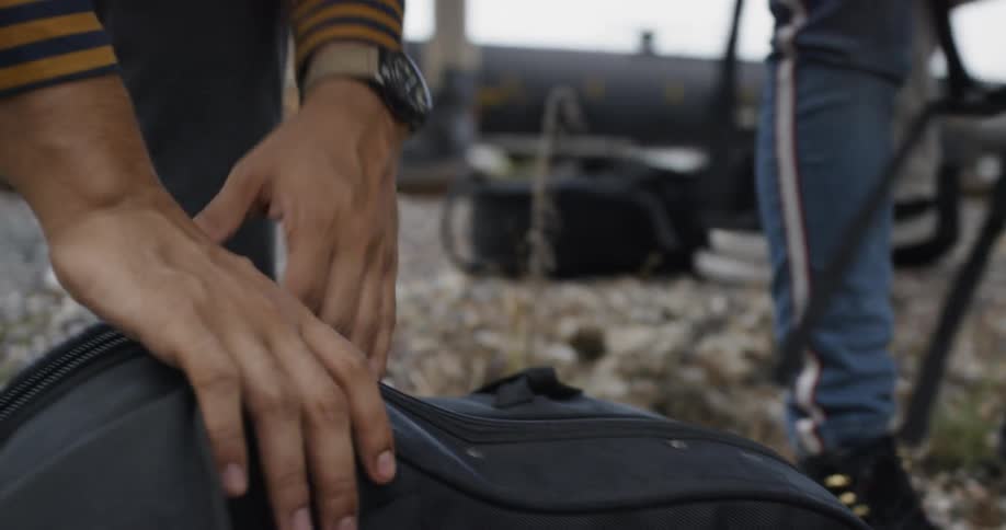 A person unzipping a saxophone case