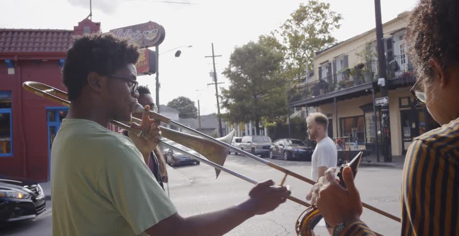 Group of young black men playing wind instruments in a street corner