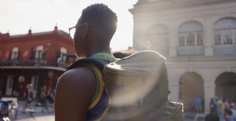 A group of young men carrying bags wander down a street