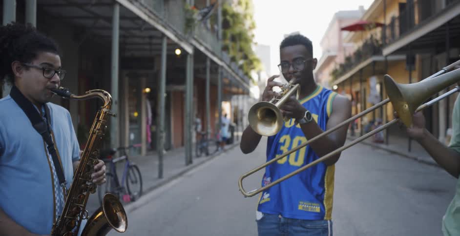 Three teenagers playing instruments in the street