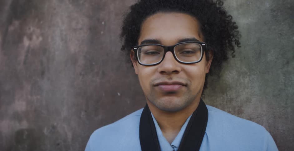 A man with glasses looks into the camera