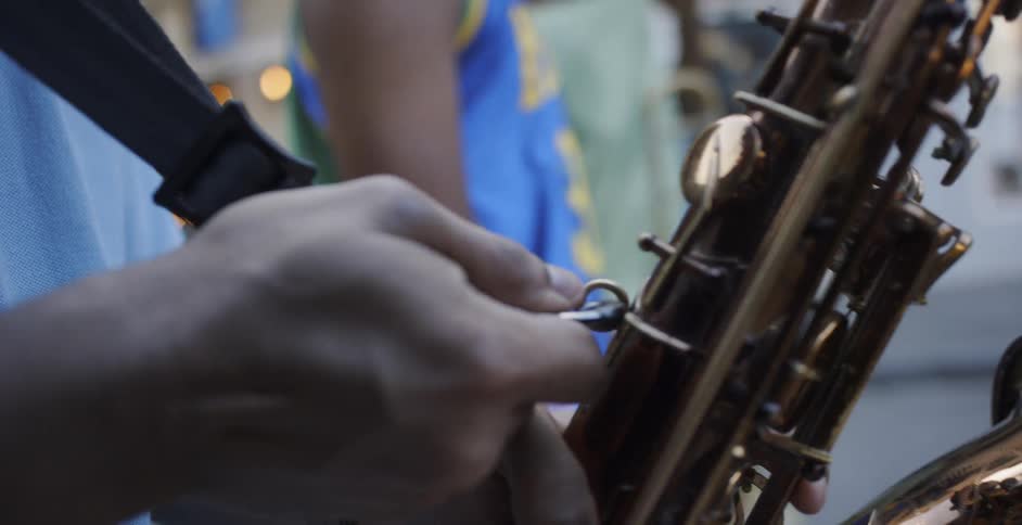 A person hooking a clip to a saxophone