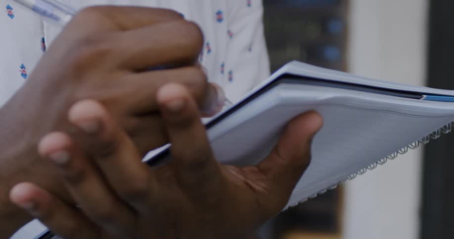 A man writes down on a notebook