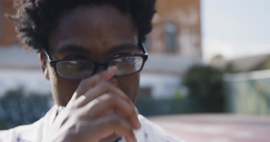 A young black is laughing and then looks ahead at something