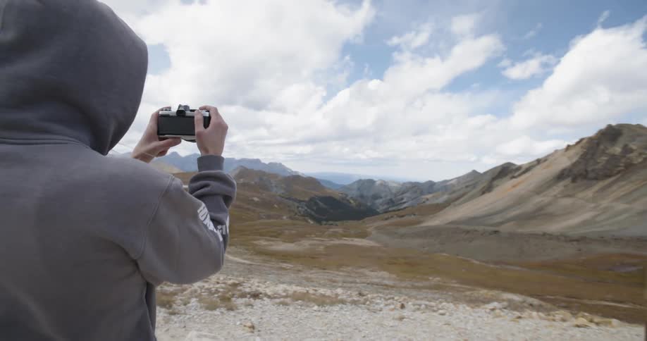 Female taking a photo of mountains