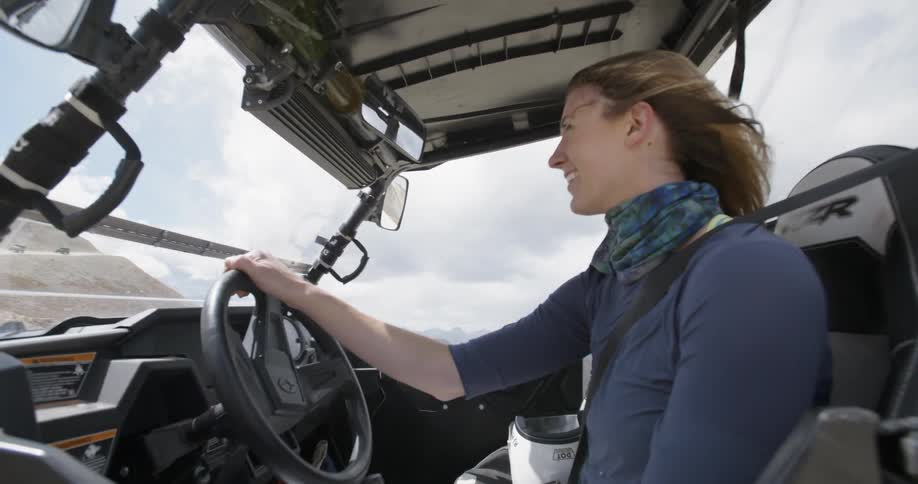 A woman sits in a vehicle on a windy day