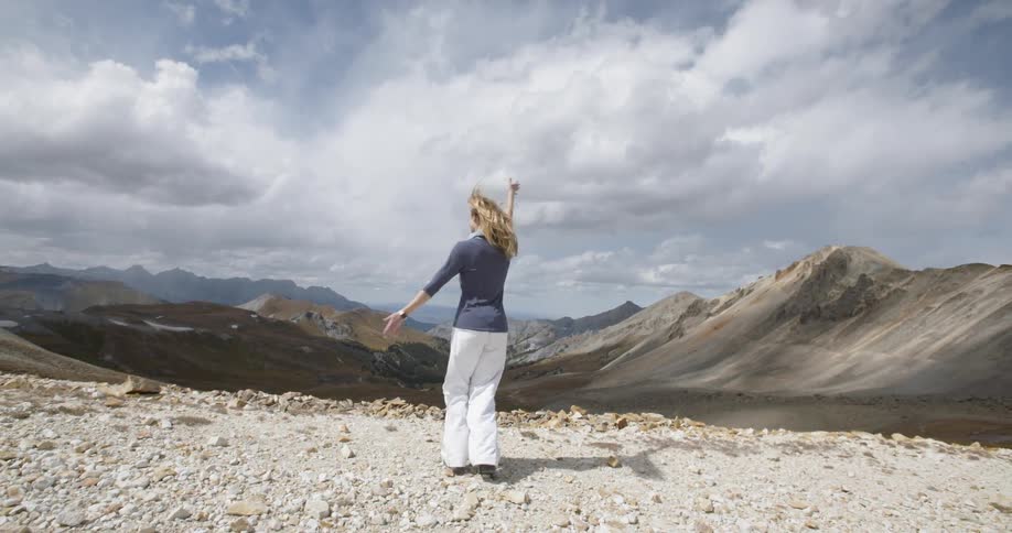 A woman dancing by a cliff