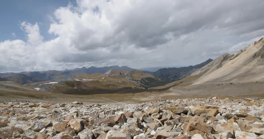 Time lapse of clouds in daytime over barren mountain landscape