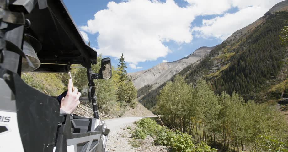 Woman takes picture on cell phone from inside of all terrain vehicle