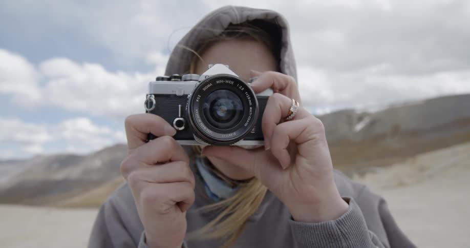 A woman staring into a camera pointed at the camera