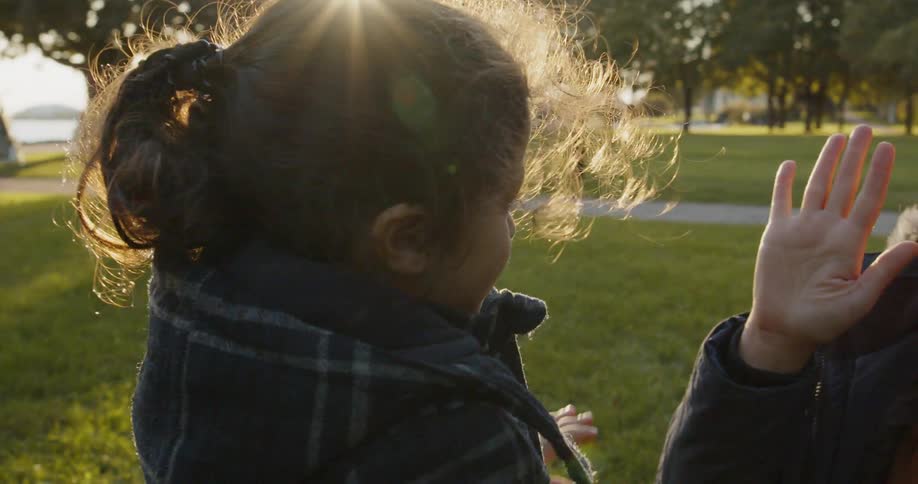 A child and a woman play fighting on grass