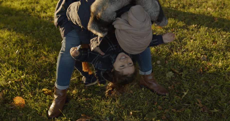 Mother and daughter playing together and having fun on the public park