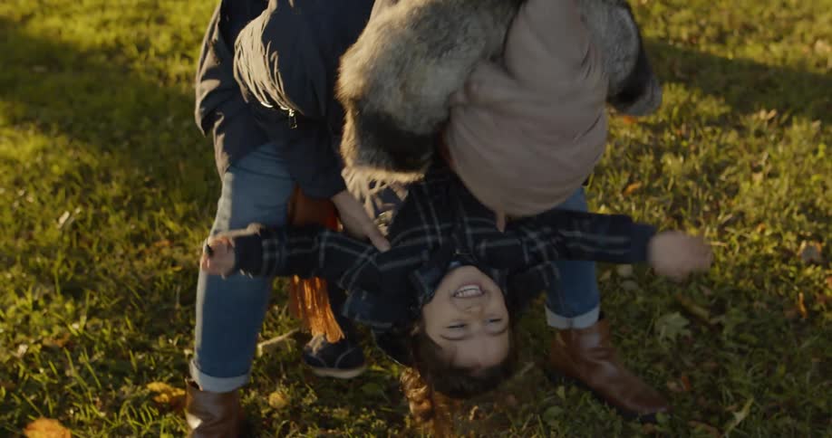 A child is repeatedly lifted up but its mother