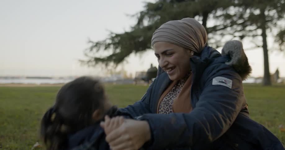 Woman and daughter play on ground in park