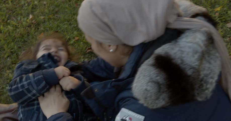 Mother plays with daughter on the lawn