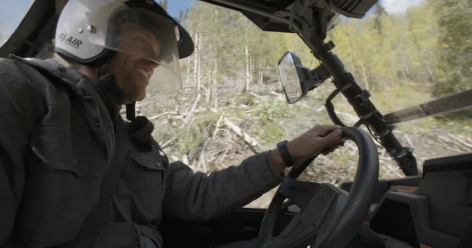 A man in a white helmet driving a vehicle