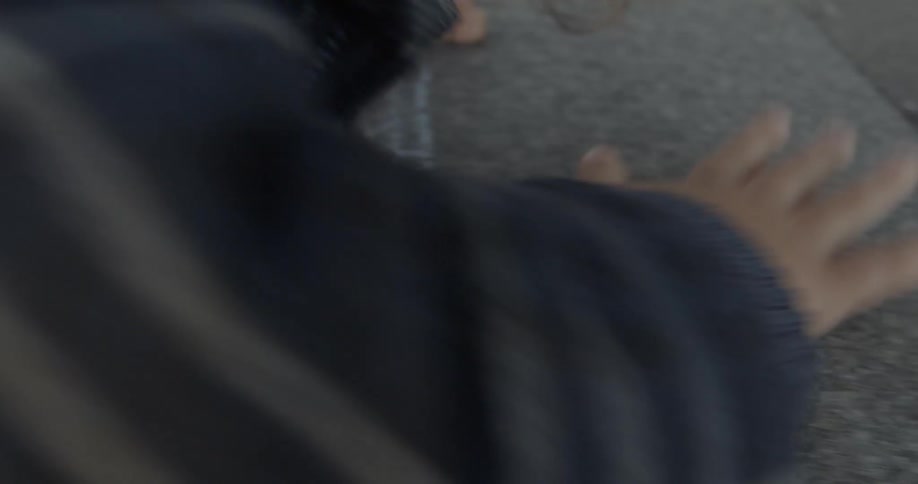 A white child grips a concrete edge and pulls himself forward