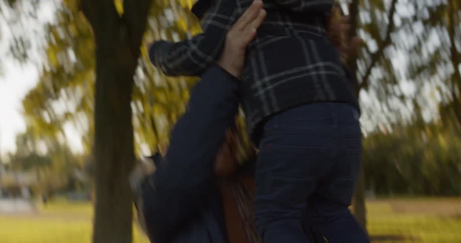 A woman throws a child into the air