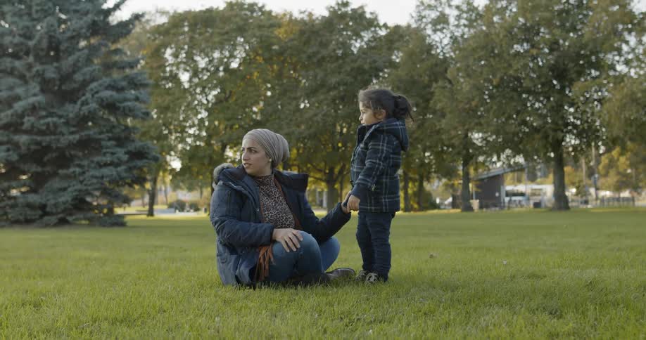 Mother and daughter talking to each other at the middle of a public park