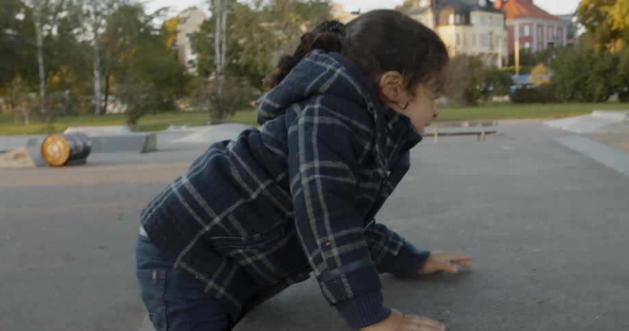 A child climbs a ramps at a skatepark