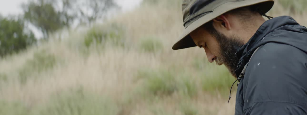 Man writing on a pad in the grass