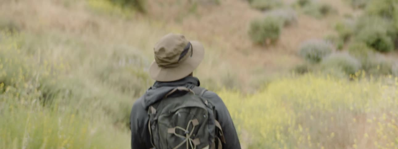 A man is walking through a rural field