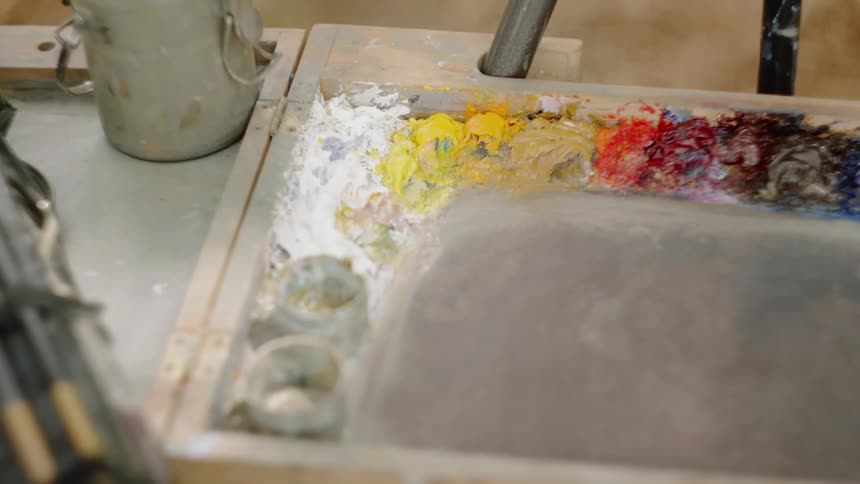 Different colored paints on an easels wooden tray palette