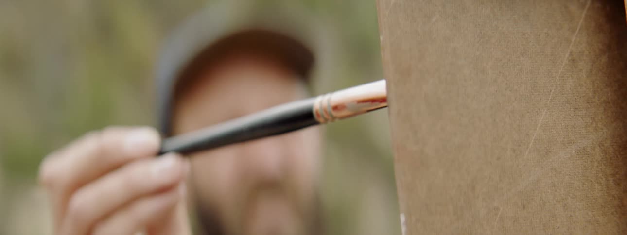 A man applies strokes with a paintbrush