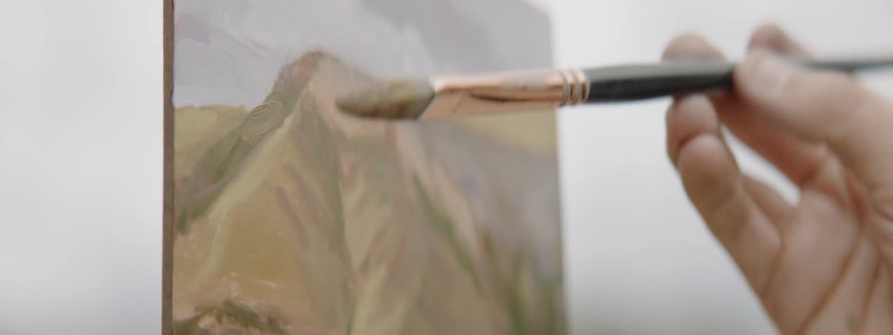 A person paints a picture on a canvas