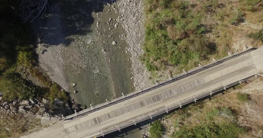 Small shallow stream flowing under a narrow bridge