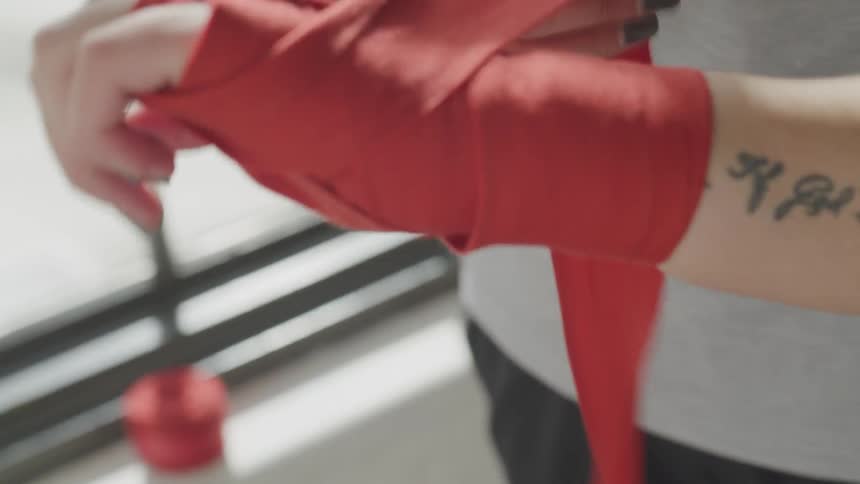 A woman wrapping their hands in tape