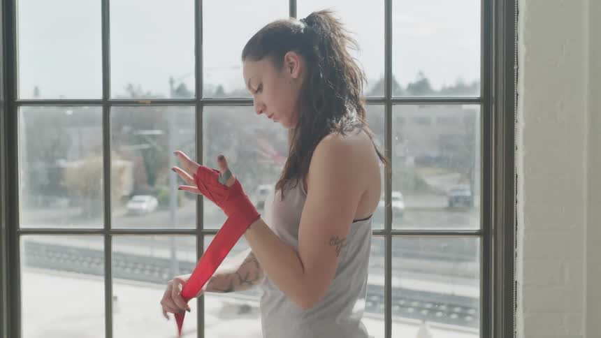 A woman wraps her hands for fighting