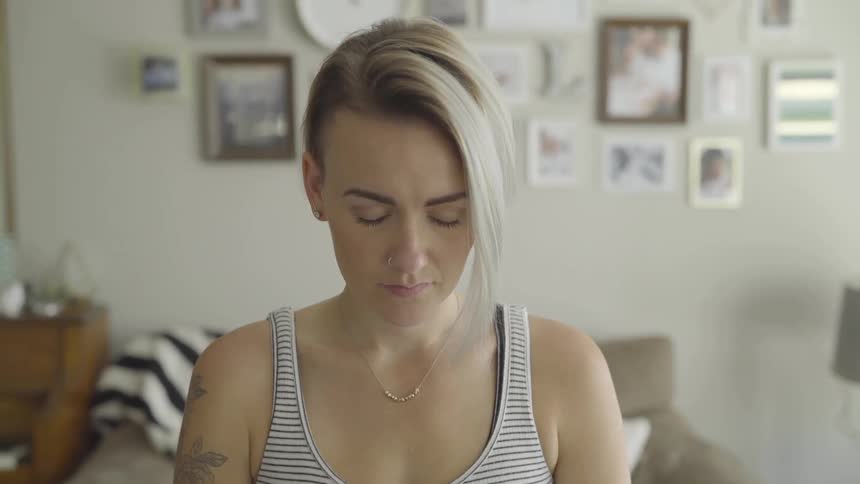 A woman indoors with her eyes close