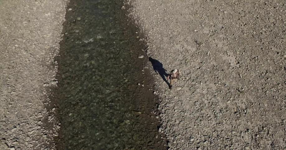A person walking next to a river