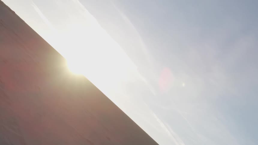 A desert with the sun and sky in the background