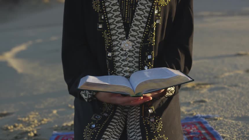 A person sitting outside holding a bible