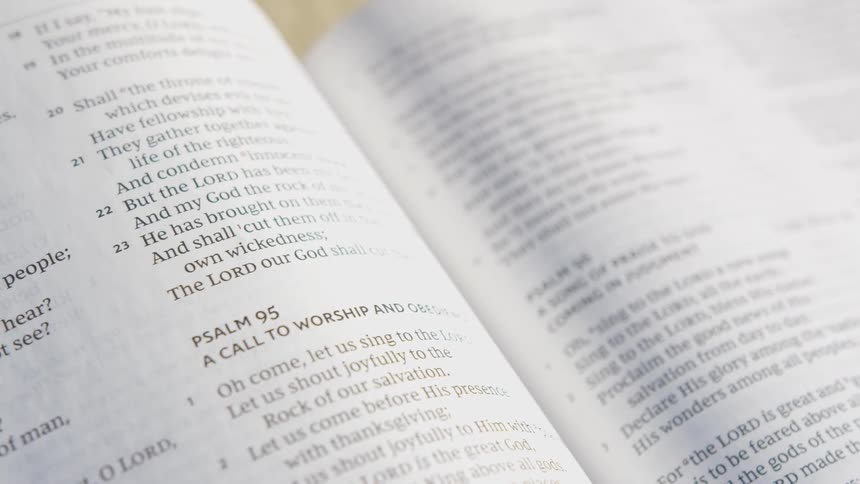 The bible open on a desk with psalms 95 and 96 showing