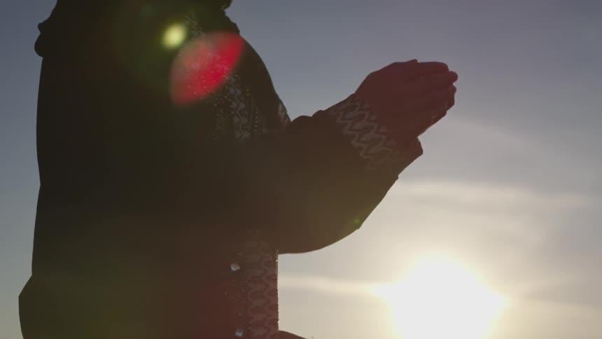 A person raises their hands to a cupped position
