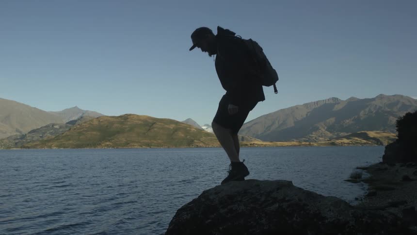 A woman is hiking along a shore