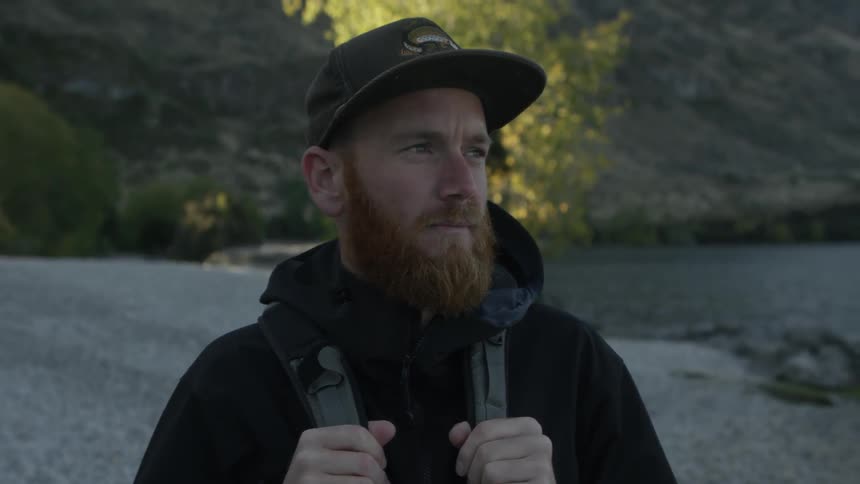 A man is hiking along the shore