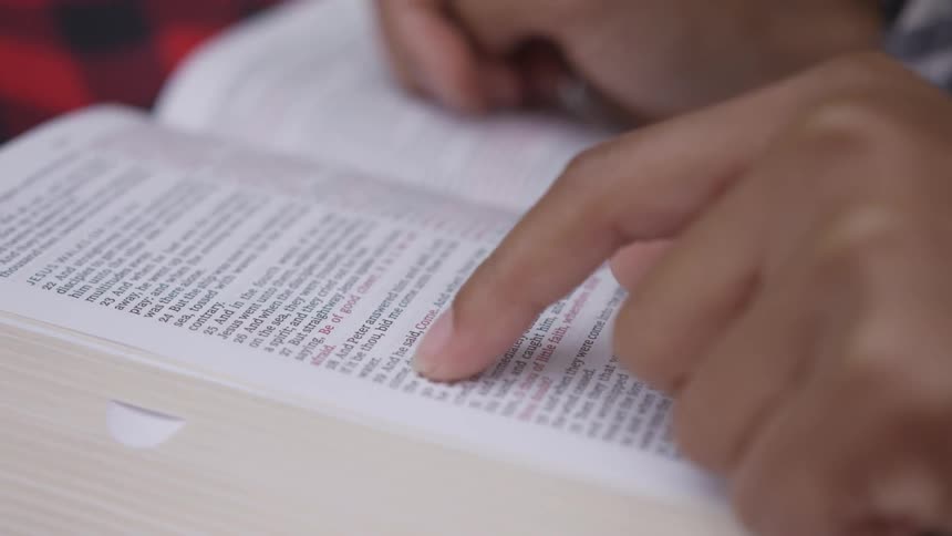 A person runs their finger over a page in a book