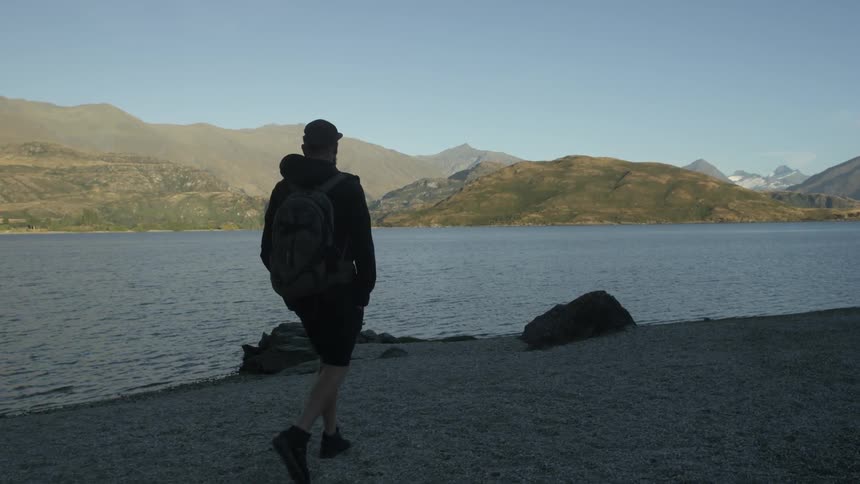 A man traveling along the shore on a sunny day