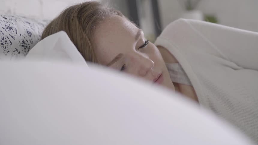 A woman laying on a pillow with her eyes close